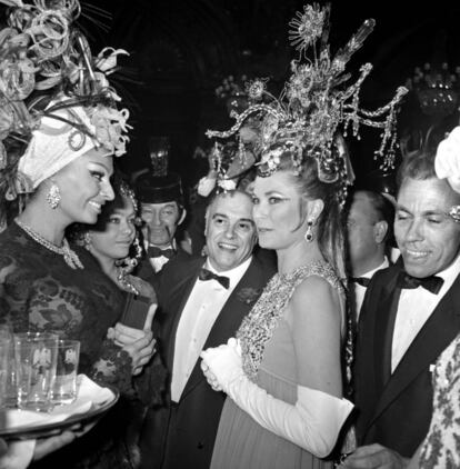 Grace Kelly, con un sombrero-lámpara y un vestido de Dior charla con Sofia Loren en una fiesta de disfraces.