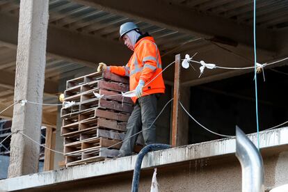 A construction worker pauses at a building site, Thursday, Jan. 26, 2023, in Boston.