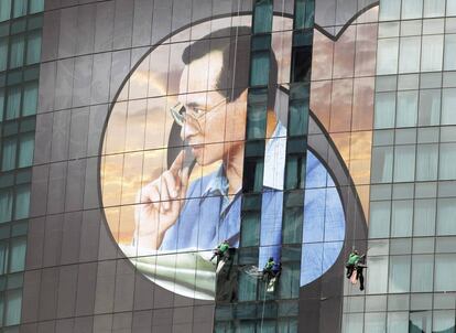 Trabajadores colocan una fotografía gigante del desaparecido rey King Bhumibol de Tailandia en un edificio de Bangkok, Tailandia.
