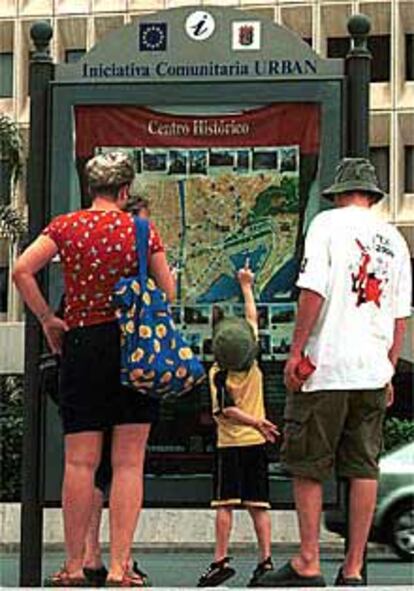 Una familia de turistas observaba ayer un plano de Málaga.