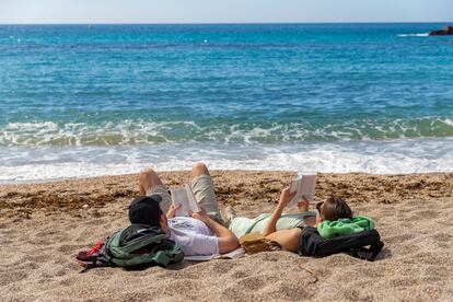 Una pareja toma el sol mientras lee, este miércoles en la playa de Cala Cortina de Cartagena (Murcia).