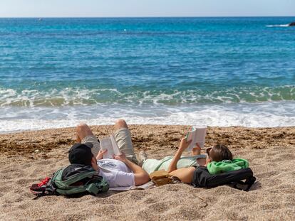 Una pareja toma el sol mientras lee, este miércoles en la playa de Cala Cortina de Cartagena (Murcia).