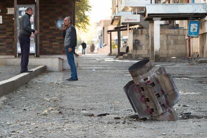 Dos hombres conversan este lunes en una calle de Stepanakert alcanzada por la artillería.