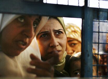 Mujeres palestinas esperan los alimentos que distribuye la ONU ante un almacén en Gaza.