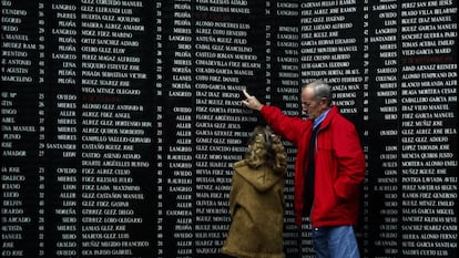 Un abuelo y su nieta, en 2004 ante la lápida que recuerda a los ejecutados por el franquismo en el cementerio de San Salvador, en Oviedo.