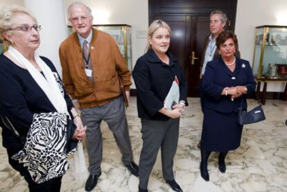 La parlamentaria popular Mari Mar Blanco (en el centro) recibe a varios miembros de Covite a su llegada ayer al Parlamento.