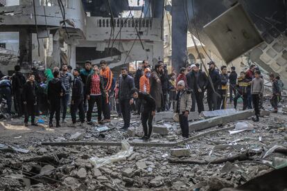 Un grupo de palestinos observa las ruinas de la mezquita del Al Huda, uno de los edificios destruidos este lunes por el bombardeo israelí en Rafah. 