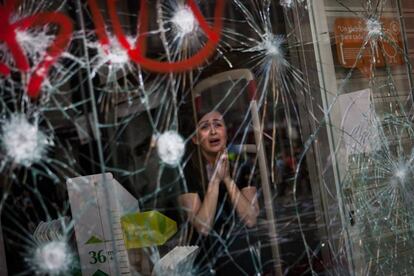 Dependienta aterrorizada ante los destrozos en su local durante la huelga general del 29 de marzo de 2012.