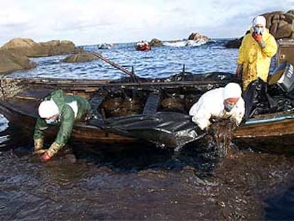 Marineros de Santa Mariña (A Coruña) recogen con las manos el chapapote vertido por el <b></b><i>Prestige.</i>