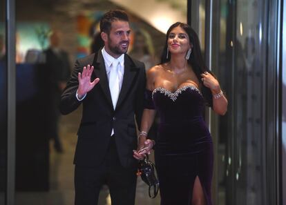 El futbolista del Chelsea Cesc Fabregas y su esposa posan en una alfombra roja.