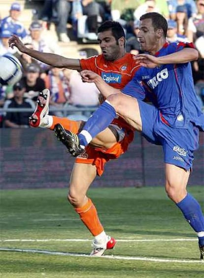 El delantero del Getafe Soldado pelea un balón con el zaguero del Recreativo Bouzón.