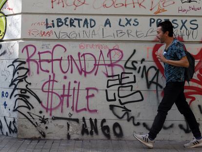Un hombre camina frente a un mural pidiendo "refundar Chile" el 27 de abril de 2023, en Santiago (Chile).