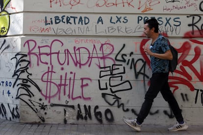 Un hombre camina frente a un mural pidiendo "refundar Chile" el 27 de abril de 2023, en Santiago (Chile).