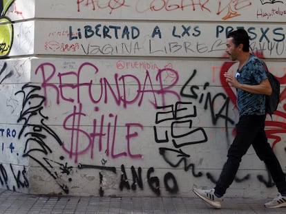 Un hombre camina frente a un mural pidiendo "Refundar Chile" el 27 de abril de 2023, en Santiago (Chile).