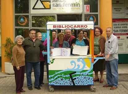 Vecinos de Usera con los libros donados, delante del albergue de San Fermín.