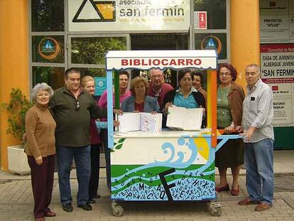 Vecinos de Usera con los libros donados, delante del albergue de San Fermín.