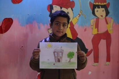 Khaled, de nueve años, sostiene un dibujo que hizo durante una sesión de pintura en su escuela en Saqba, en Guta Oriental. Representa a su casa, que fue destruida. “Era una casa muy hermosa, en la que mi familia solía vivir junto con mis abuelos. Salimos de nuestra casa hace tres años y vinimos aquí. No he visto a mi abuela ni a mi primo desde entonces".