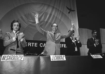 Jacques Chirac, en 1976, entonces primer ministro, hace la señal de la victoria acompañado por los miembros de UDR Nicolas Sarkozy (izquierda), delegado de juventud; Alain Aubert (segundo por la derecha), delegado nacional de la juventud, e Yves Guena, secretario general de la UDR.