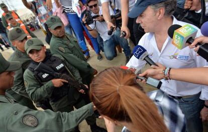Santos saluda a un miembro de la Guardia Nacional Bolivariana (GNB), durante su visita al paso fronterizo de Paraguachón (Colombia).