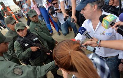 Santos saluda a un miembro de la Guardia Nacional Bolivariana (GNB), durante su visita al paso fronterizo de Paraguach&oacute;n (Colombia).