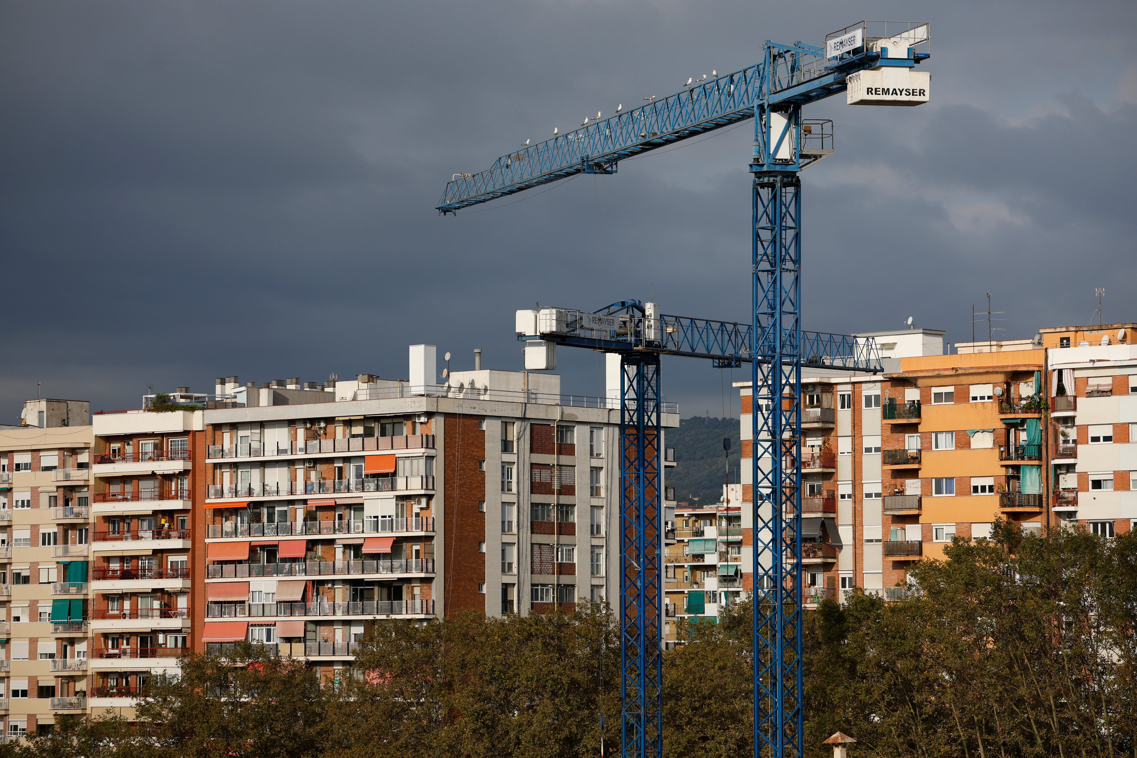 Edificios de viviendas y, en primer plano, unas grúas de una obra en el barrio del Poblenou de Barcelona.