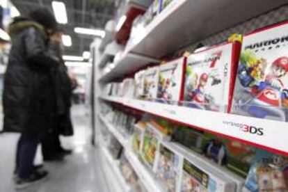 Varios clientes observan una estantería llena de juegos para la videoconsola Nintendo 3DS en una tienda de electrónica de Tokio (Japón). EFE/Archivo