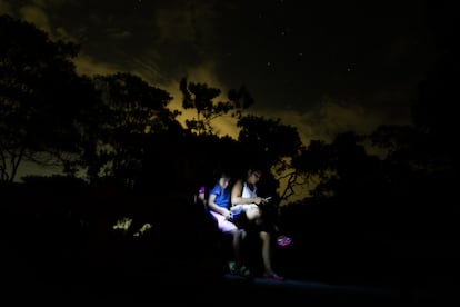 Niñas y mujeres escuchan al sabio de la comunidad, Santiago Pérez, contar historias de su pueblo bajo las estrellas, en Centro Arenal. 