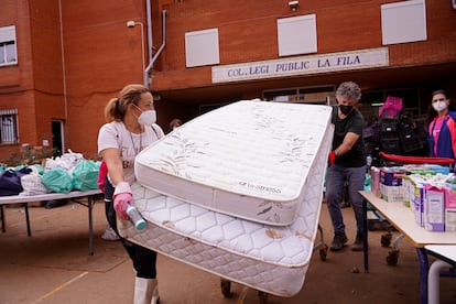 Colchones, ropa y alimentos se clasifican en una escuela utilizada como centro de distribución para las personas afectadas por las inundaciones en las afueras de Valencia, este lunes.