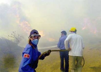 Varios voluntarios trabajan en la extinción del fuego en el macizo del Montgrí, cerca de Bellcaire.