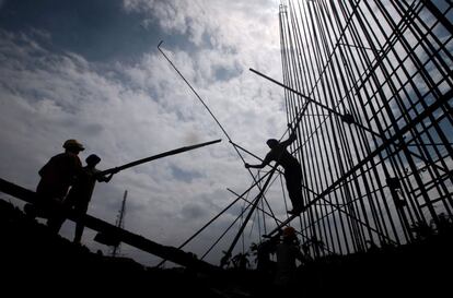 Varios obreros de la construcción trabajan en la edificación de un puente en Yakarta (Indonesia).