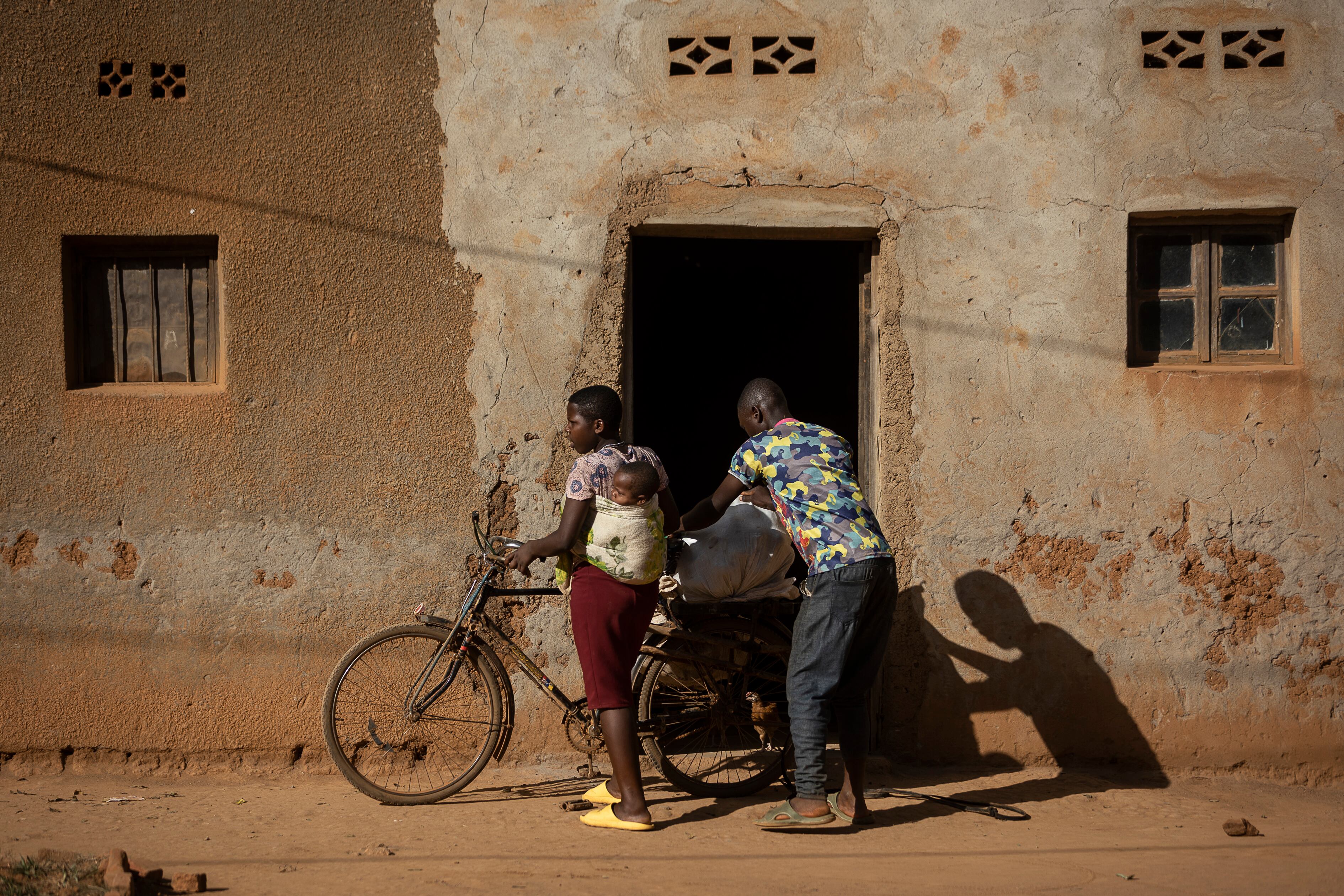 Dos jóvenes, una de ellas con su bebé en la espalda, en las calles del pueblo de Jurú, en Ruanda.