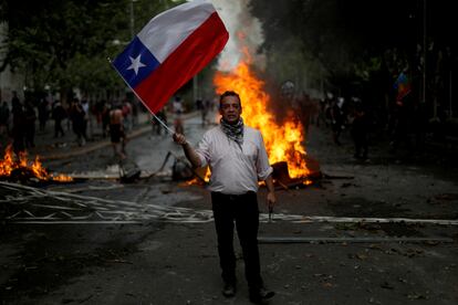 un hombre con una bandera chilena durante una manifestación en el estallido social de 2019