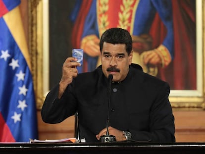 Maduro holds a copy of the Venezuelan Constitution during a speech.