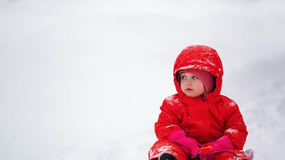 Un niño juega con su trineo en la nieve.