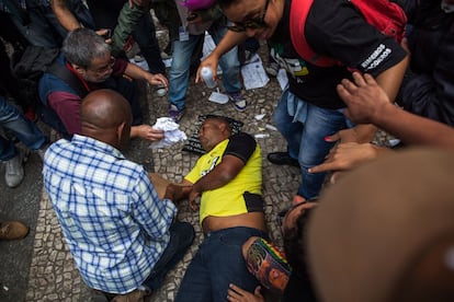 Homem é atendido por um grupo durante o protesto. Ele desmaiou por causa do gás atirado pelos policiais.