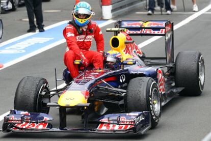 Fernando Alonso se sienta sobre el coche de Mark Webber después de la carrera.