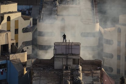 Un oficial de policía observa desde el techo durante el motín.