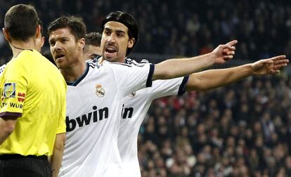 Los jugadores del Real Madrid Xabi Alonso y Shami Khedira protestan a Clos Gómez.