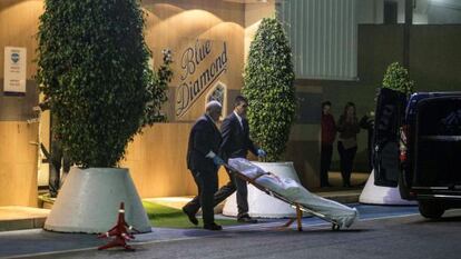 Trabajadores de la funeraria sacan los cuerpos de los dos fallecidos.
