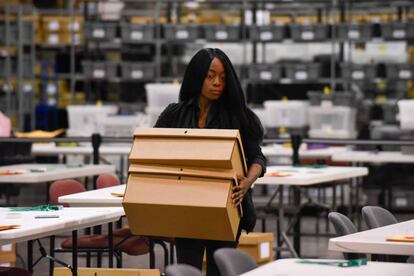 Una mujer sostiene una caja con papeletas de las elecciones legislativas en Palm Beach, Florida.