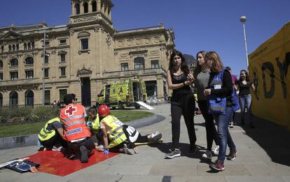Profesionales sanitarios atienden a los heridos en el exterior del Victoria Eugenia, con el teatro al fondo.