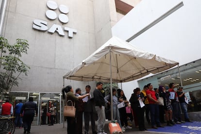 Personas esperan su turno para ingresar a realizar sus trámites en las oficinas del SAT.