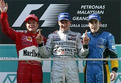 Rubens Barrichello, Kimi Raikkonen y Fernando Alonso, en el podio del circuito de Sepang.
