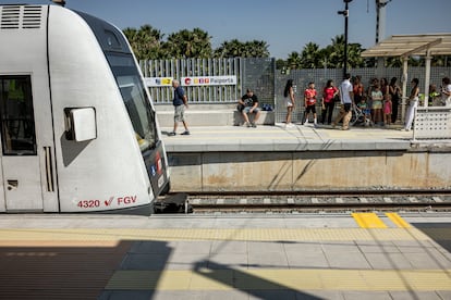 Varias personas se protegen bajo la escasa sombra en el andén de Paiporta en dirección a Torrent.