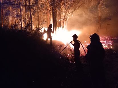 Miembros de la Unidad Militar de Emergencias (UME) intentan sofocar el fuego en la localidad asturiana de Navelgas, en la noche del viernes.