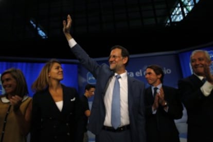 Rajoy saluda al público en la convención del PP en Málaga, rodeado de Cospedal, Aznar y Arenas.