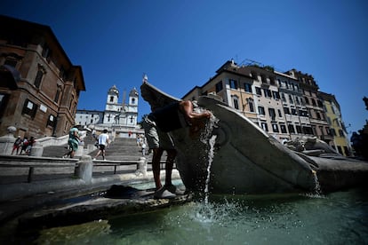 Un hombre se refresca en la Fuente de la Barcaza, situada en la Plaza de España, este lunes en Roma.