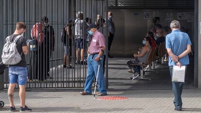 Varios usuarios esperan para acceder al centro de salud El Alamillo, este martes, en Sevilla.