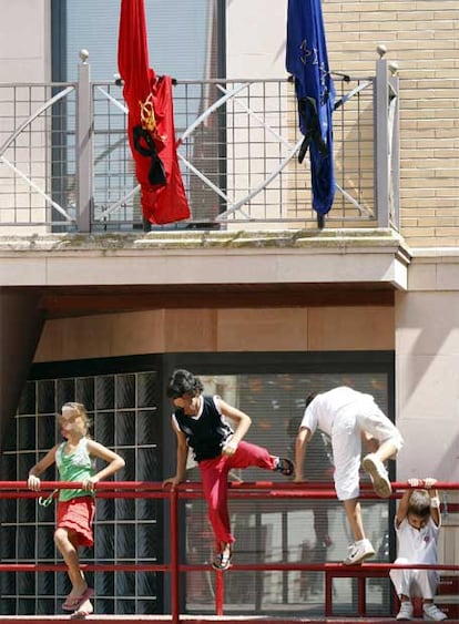 Unos niños juegan en Cabanillas bajo las banderas a media asta.