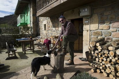Josean Barturen corta leña ante la puerta de su casa en el pueblo cántabro de San Miguel de Aguayo.